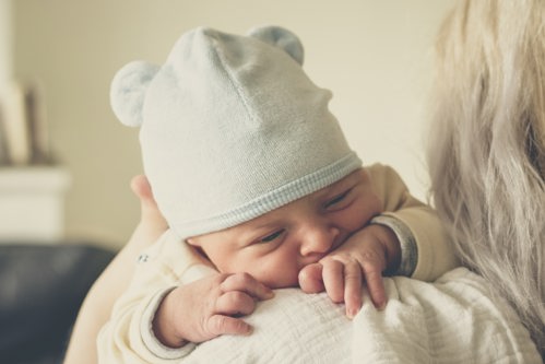 An infant resting on parent's shoulder.